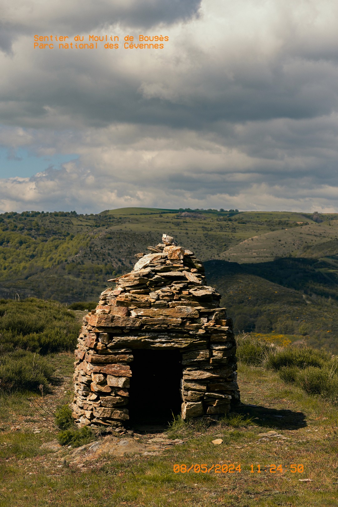 Abri en pierres sur les hauteurs du Parc national des Cévennes, sous un ciel nuageux.
