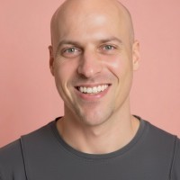 Profile portrait of a man in a white shirt against a light background