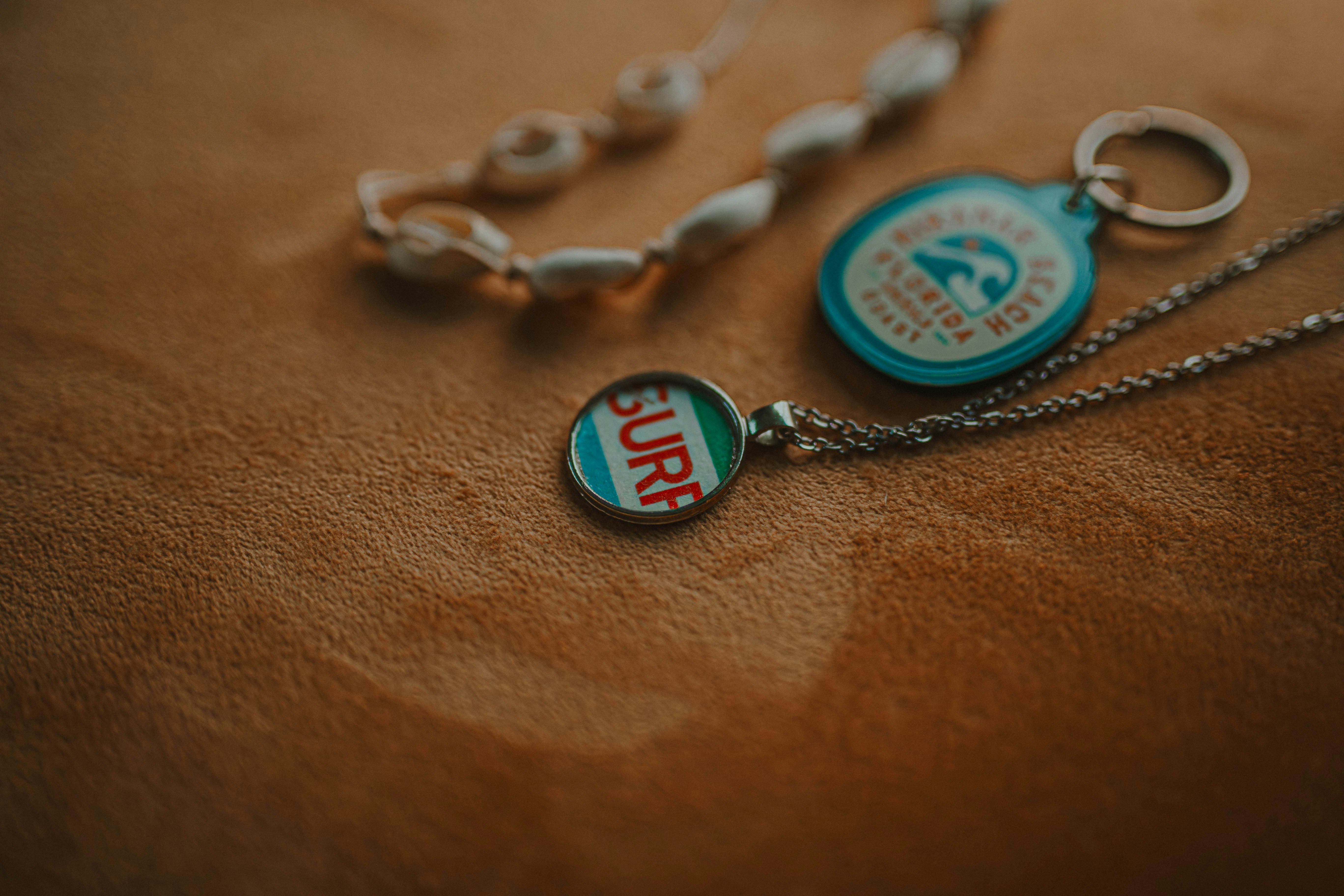 Surf necklace and pearl bracelet on brown surface