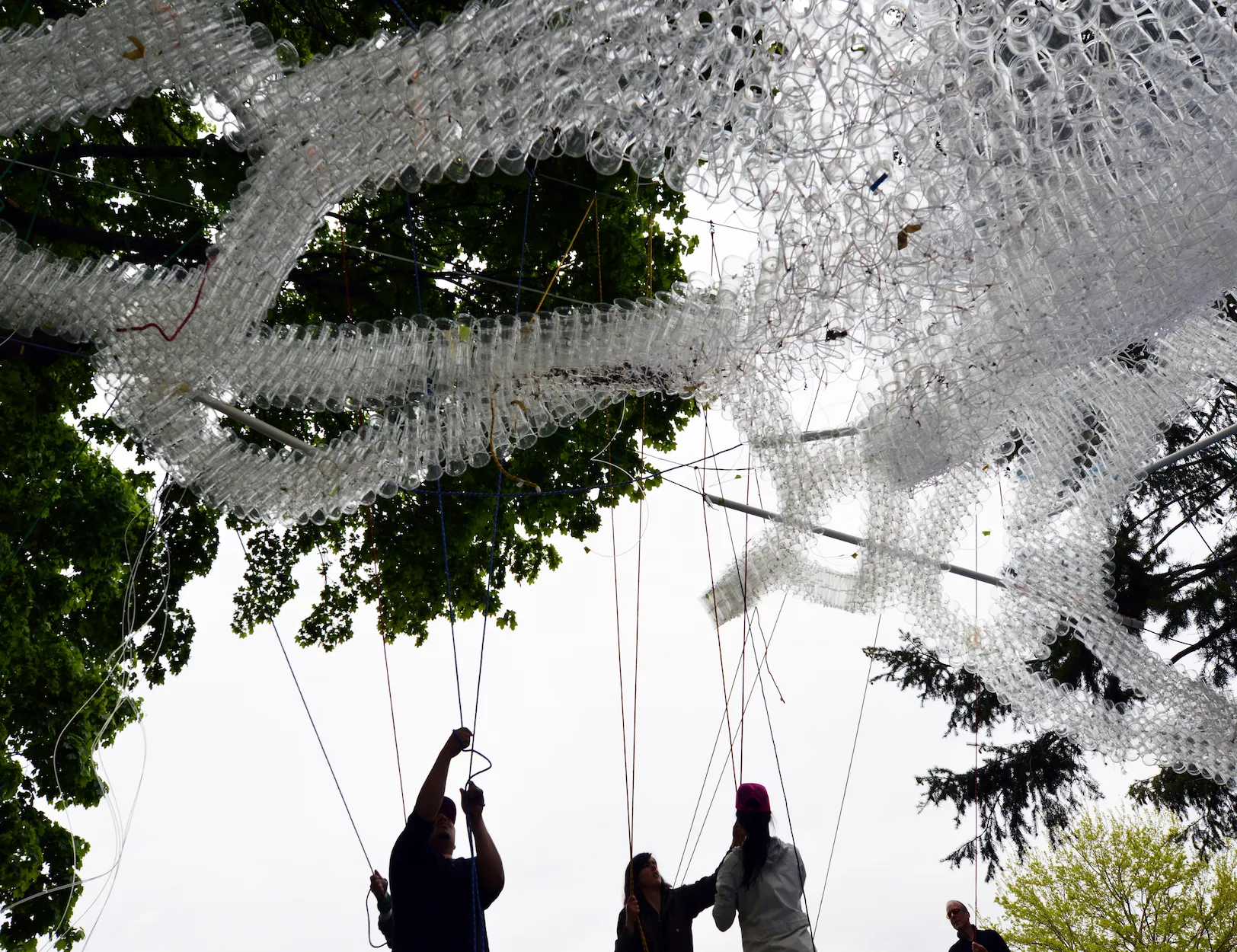 Installation pulley system with volunteers to elevate plastic cup ribbons