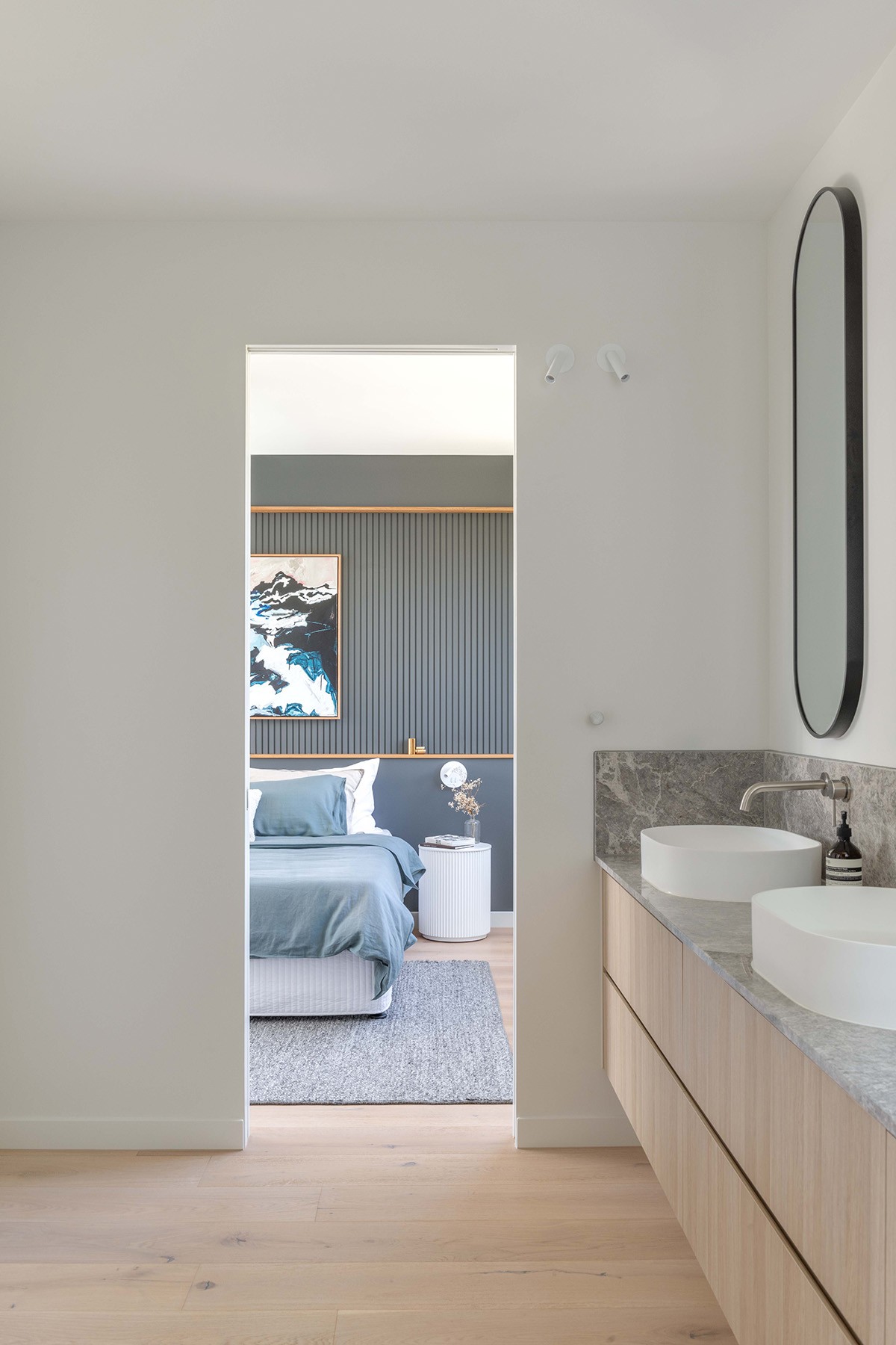 Ensuite and bedroom connection at The Stables, with timber joinery, stone vanity, and a clear sightline linking private spaces.