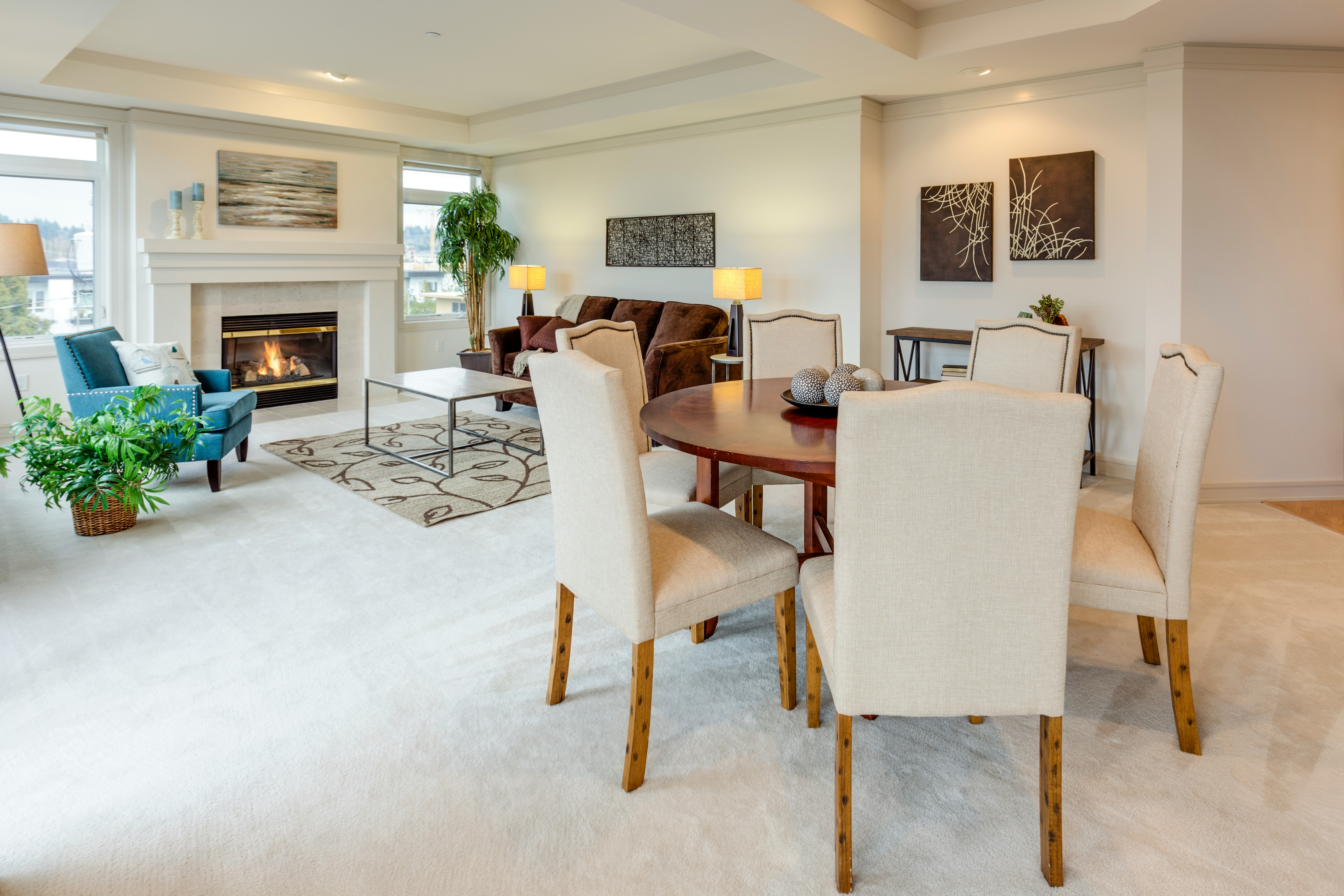 round brown wooden table with six white leather padded chairs