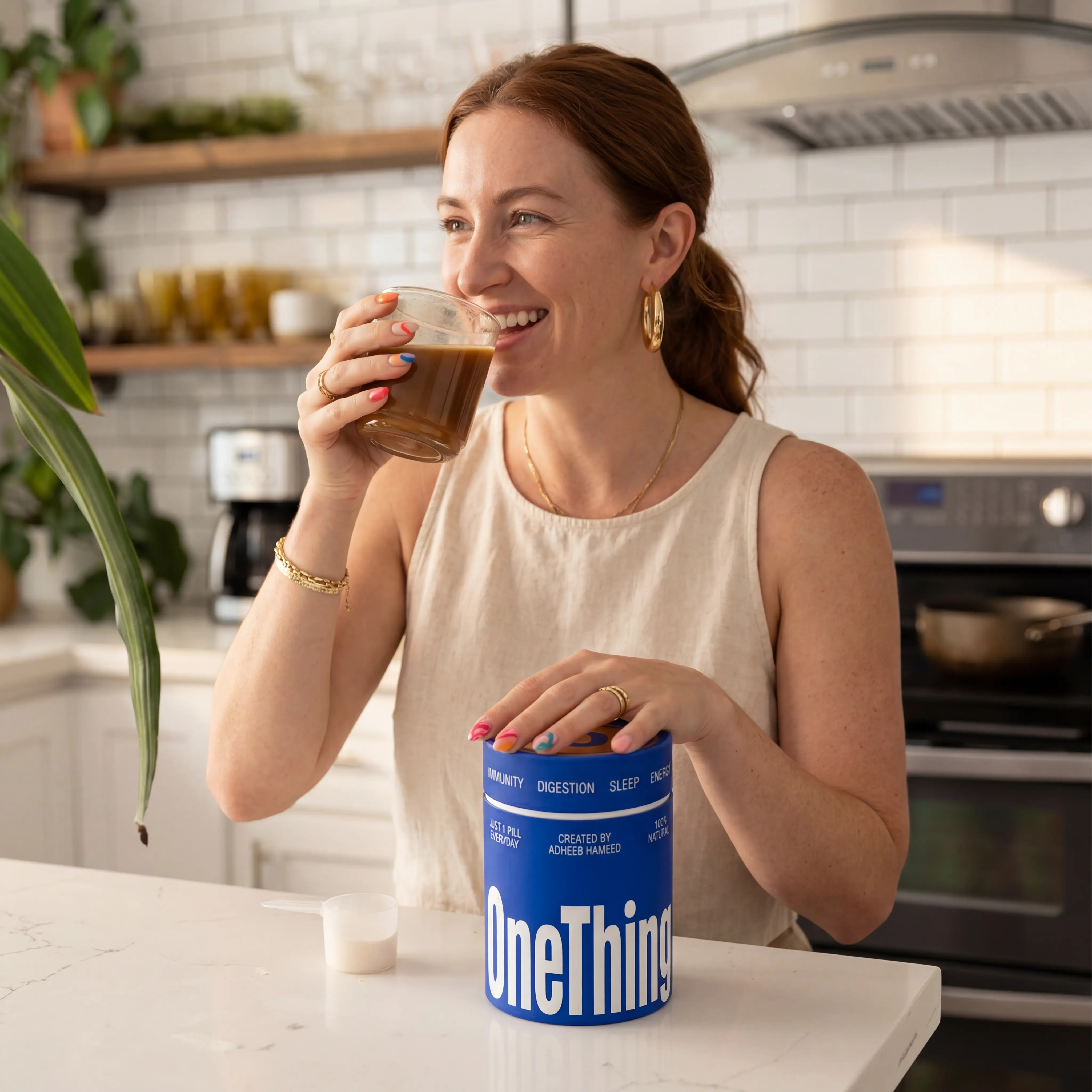 woman drinking coffee while having hands placed on the supplement box