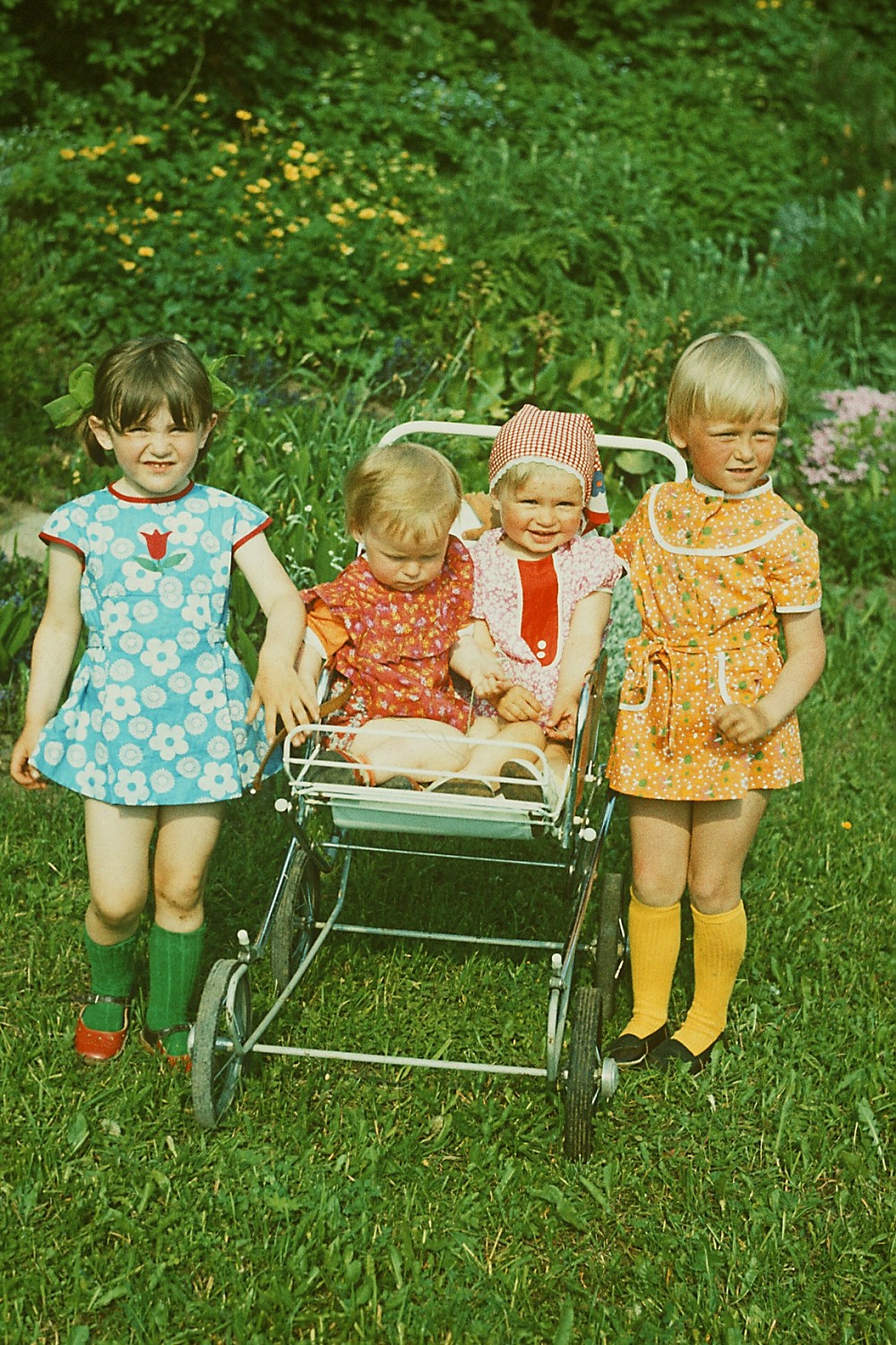 Kaks suuremat last ja kaks väikest last nende vahel vankris