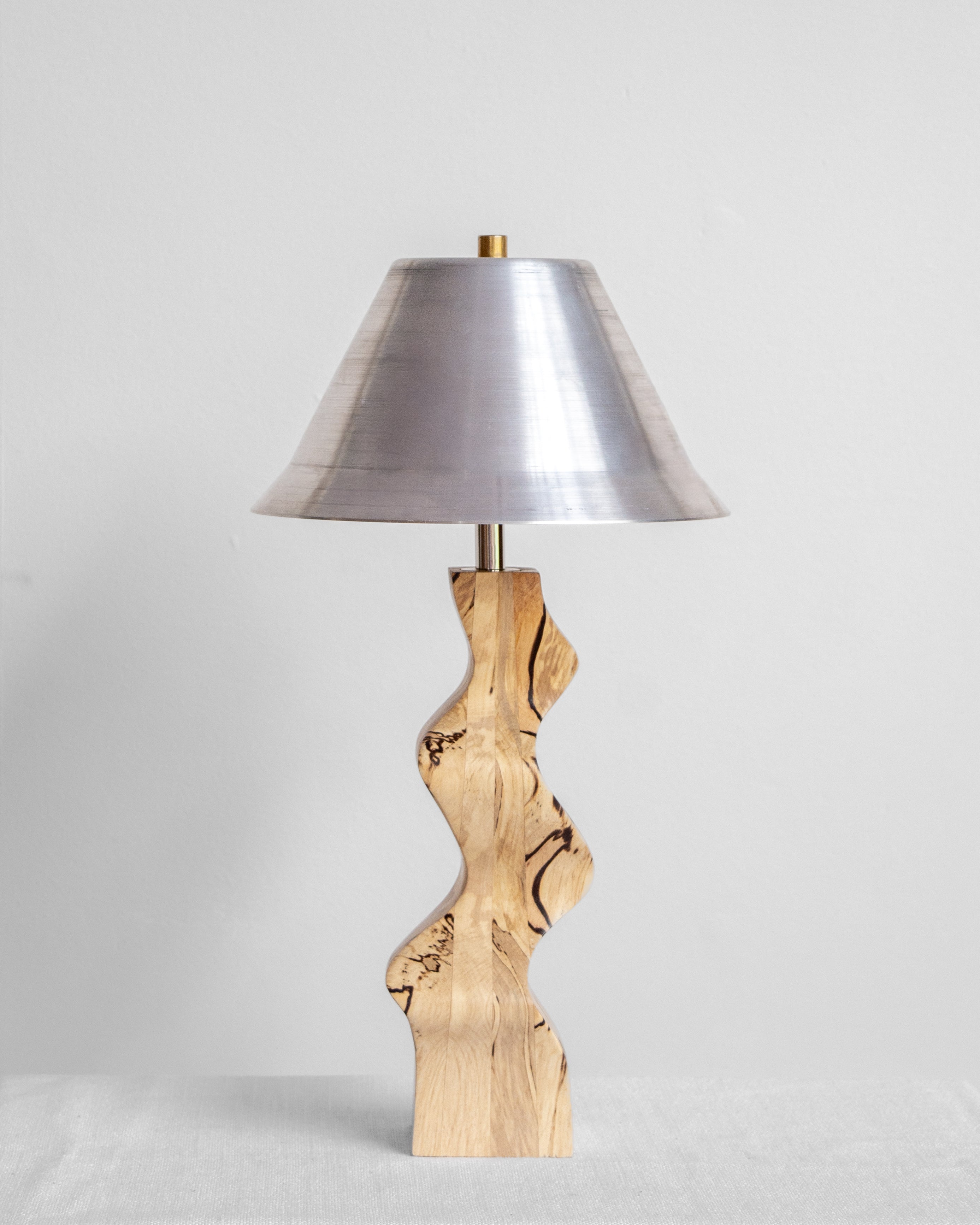 Rippled Desk Lamp with Spalted base and Aluminium shade on a light grey background with UK, EU and US/CA wiring available on white background Wilkinson & Rivera