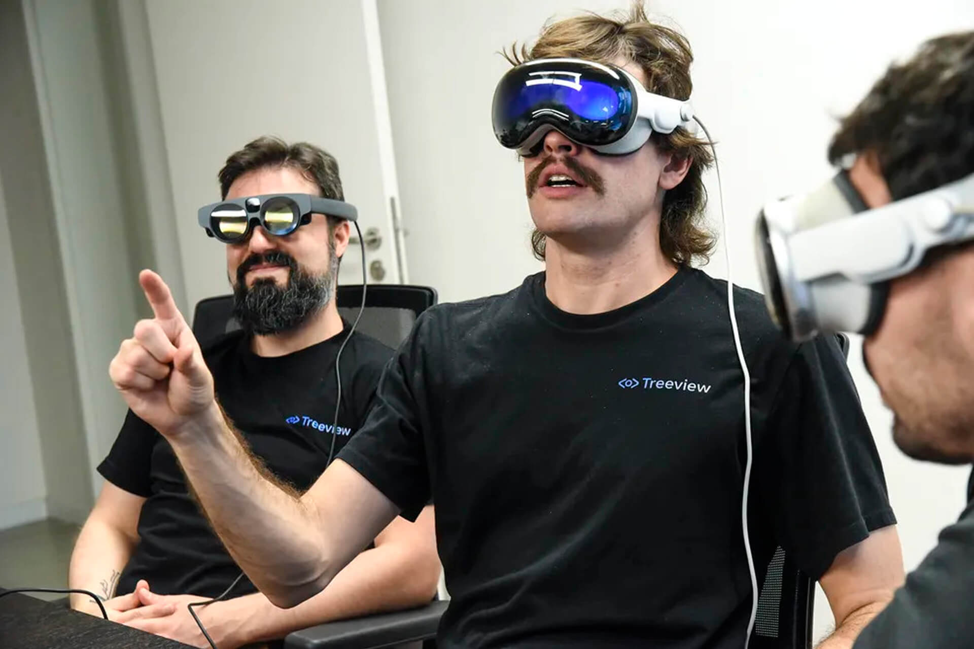 A large group photo of diverse team members gathered in an industrial-style space with arched ceiling.
