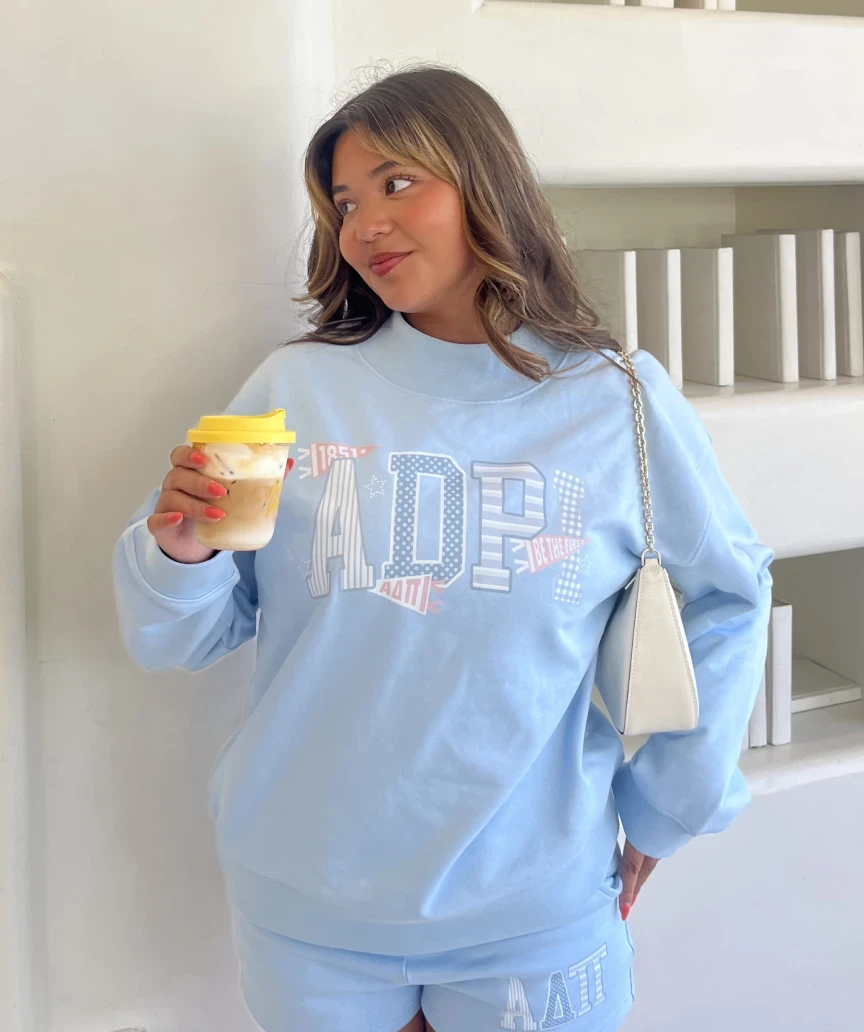 Clarissa, wearing a blue sorority set combining multiple shades and patterns.
