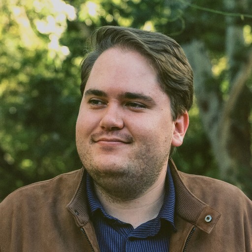 Alex smiling in a brown suede jacket