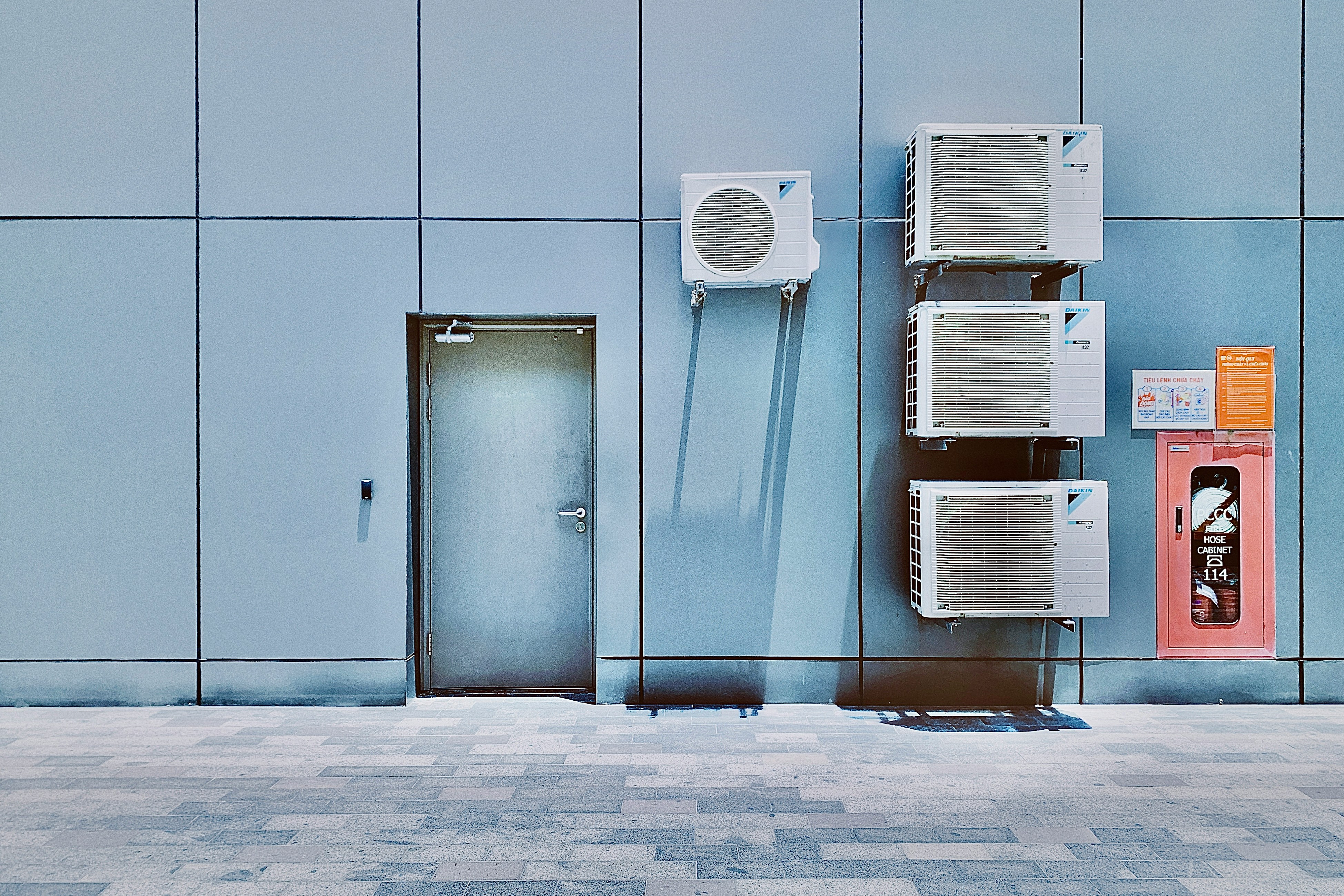 a couple of air conditioners sitting on the side of a building