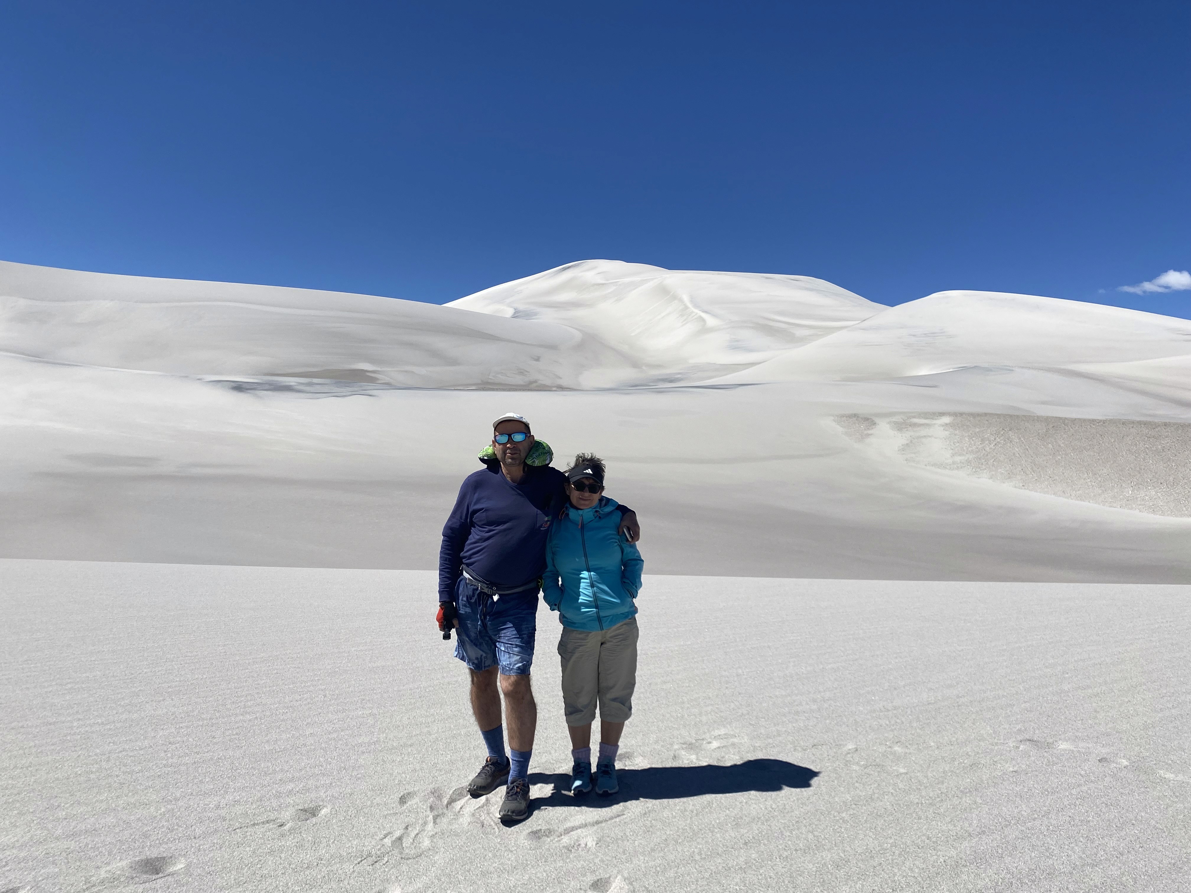 Mujer sentada sobre un tronco frente a una cascada doble en un bosque frondoso de Argentina.