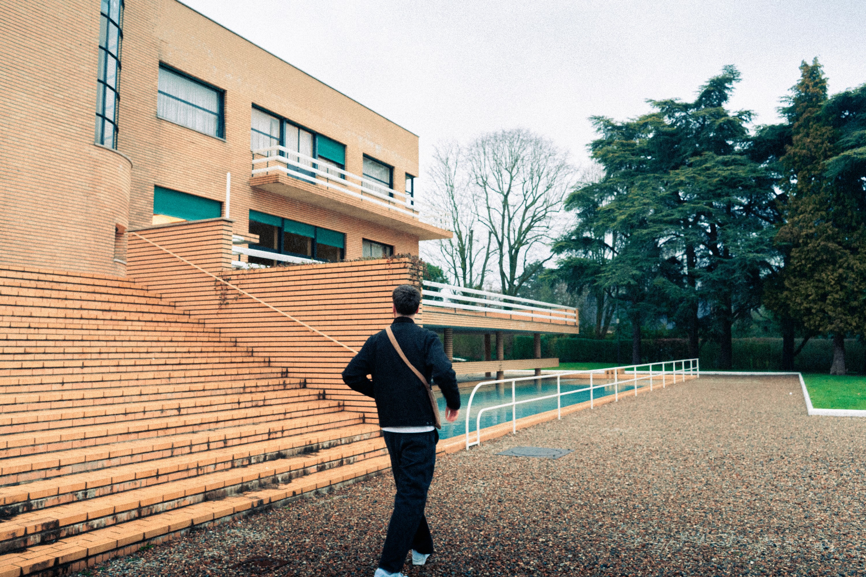 A close-up of a pink cocktail in a martini glass, set against a nighttime background with soft, blurred colors.