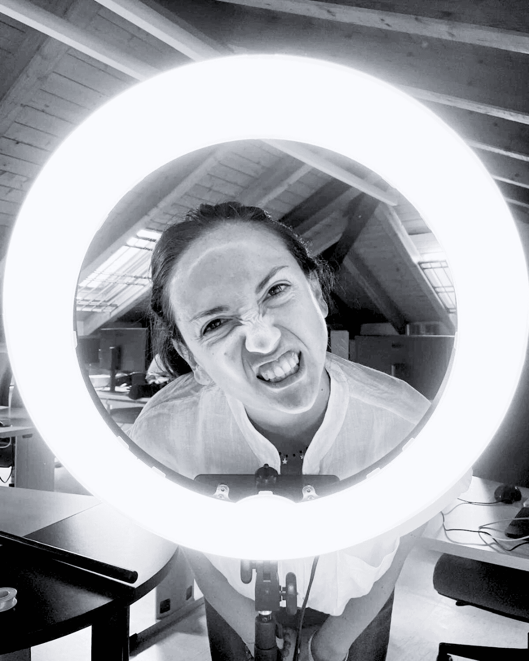Foto in bianco e nero di donna al centro di una ring lite in un set fotografico per strategia social