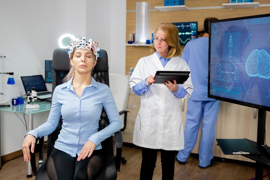 A patient wearing headset for the procedure and the doctor analysing the headset.