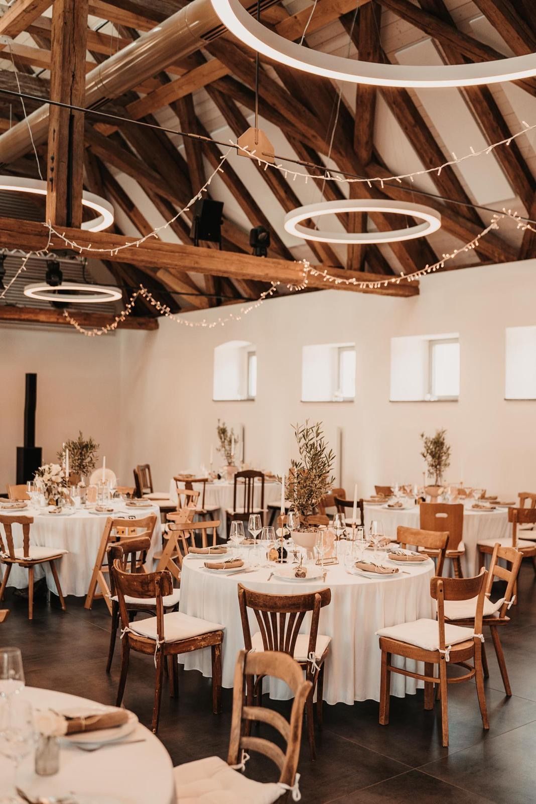 Hell gestalteter Festsaal mit individueller Bestuhlung und runden Tischen vom Hochzeitsverleih fruchtbar mobil
