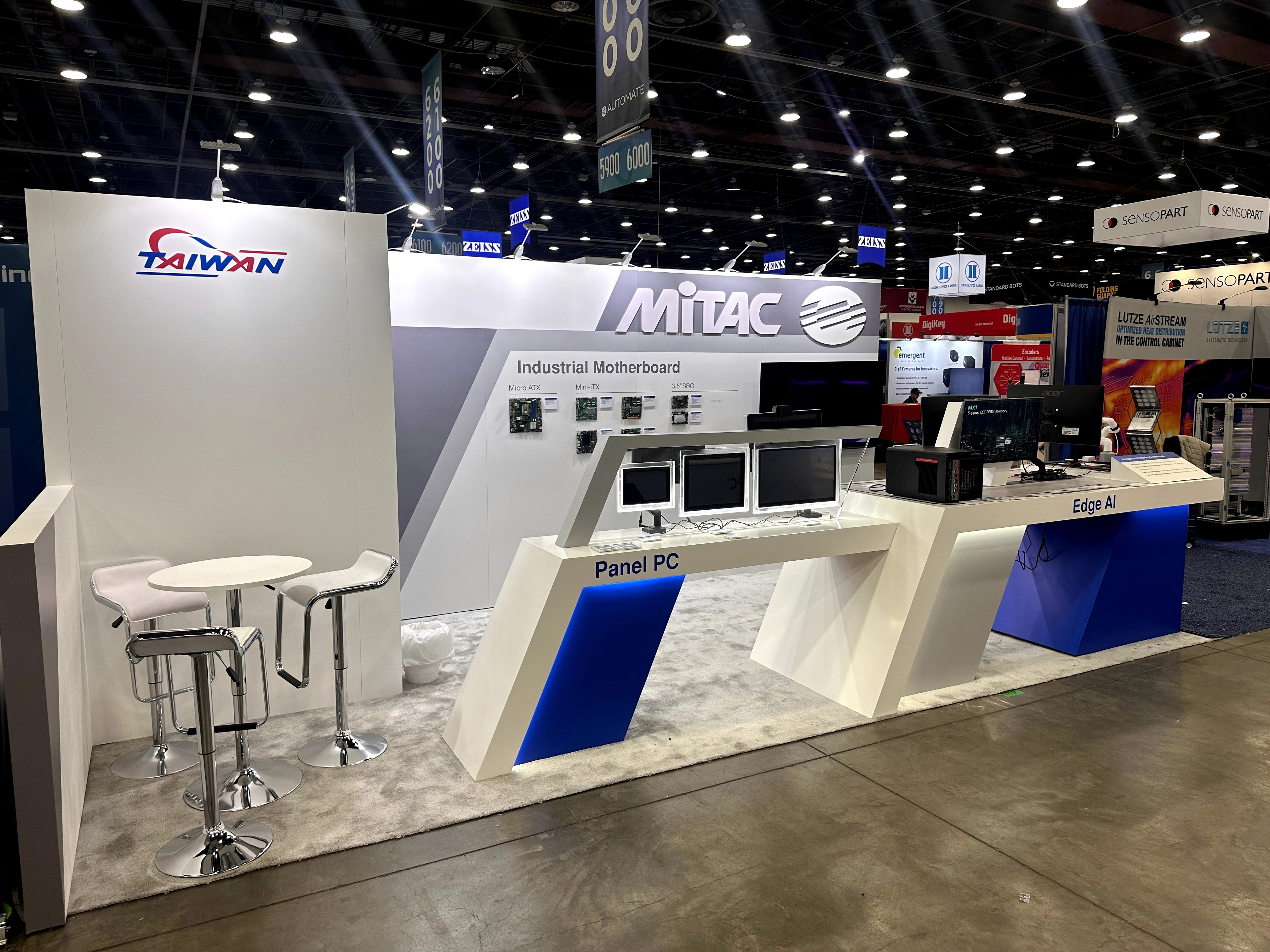 Panel PC demo counter and seating area inside the MITAC booth at Automate 2025