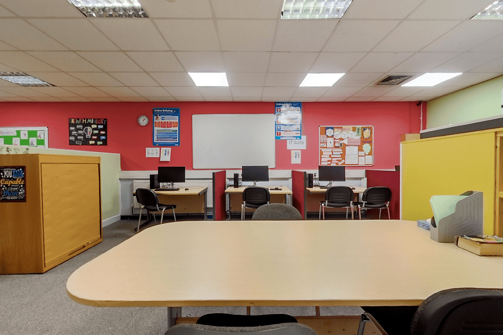 Modern classroom equipped with multiple computers, set up to facilitate technological learning