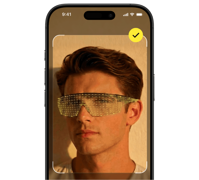 Mobile app screen showing a man wearing protective glasses with a digital face-mapping overlay, prompting the user to hold the mobile device steady.