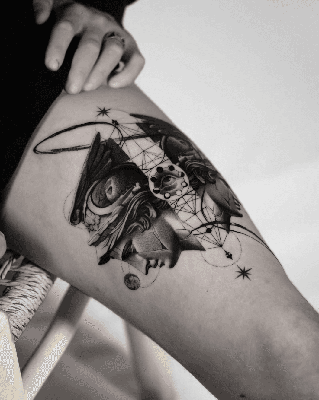 Abstract thigh tattoo of classical bust with geometric lines.