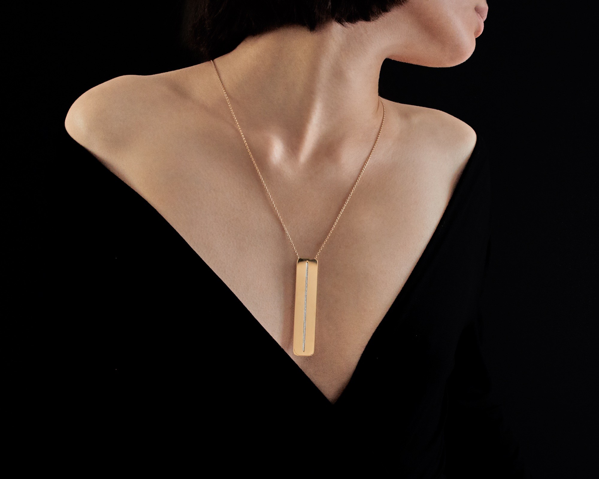 Pendentif Gravity porté en collier sur fond noir