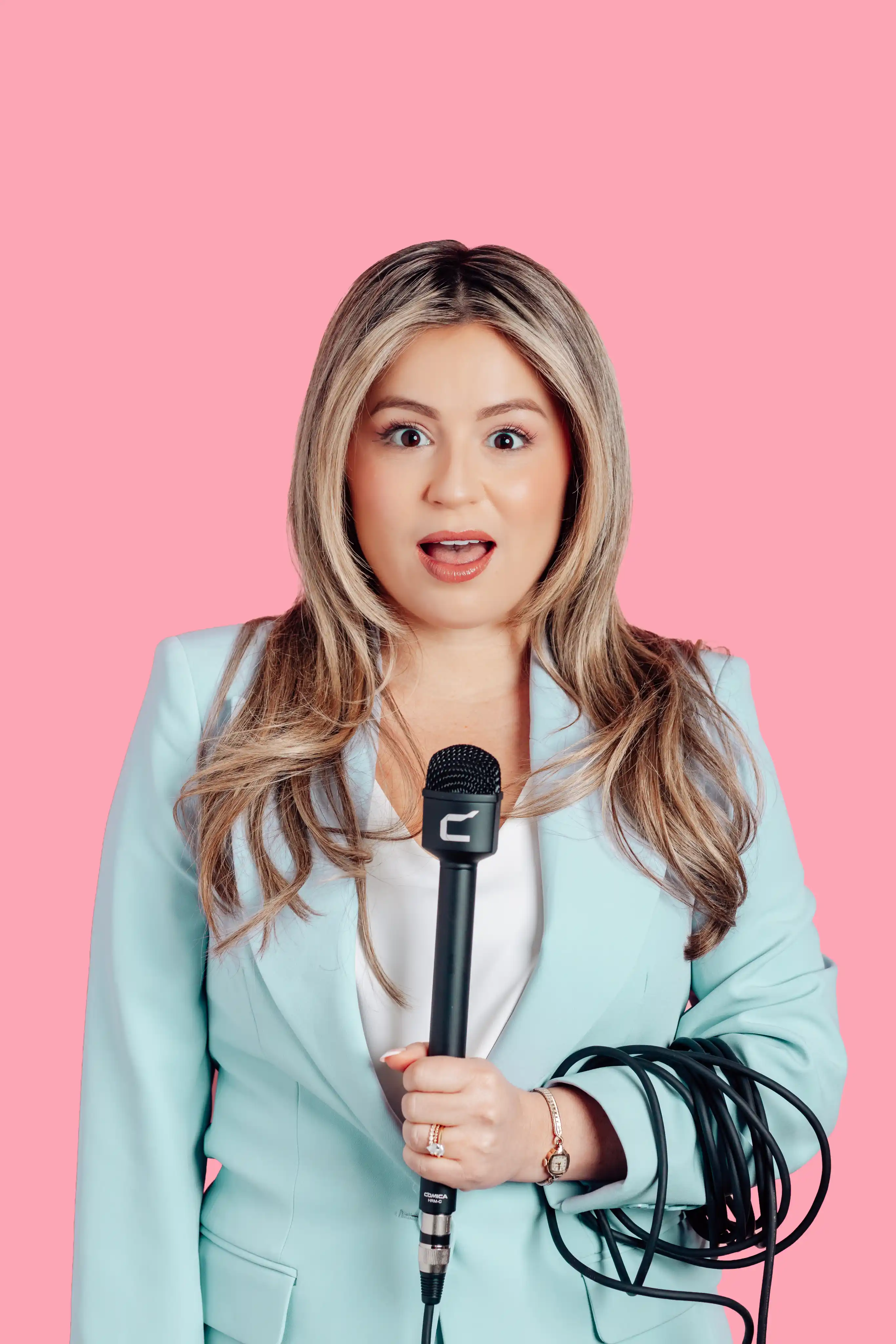 Expressive portait on pink background of woman with a microphone at a Tampa photo studio