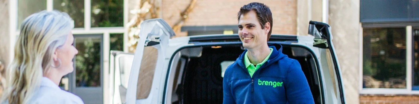 A Brenger driver handing over a delivery to a customer at her front door