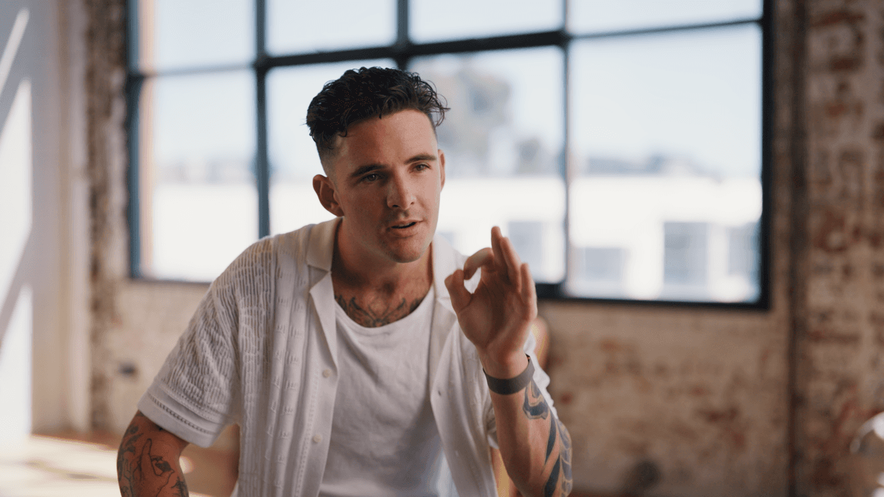 Tom Noske wearing a white shirt with sunlight in the background