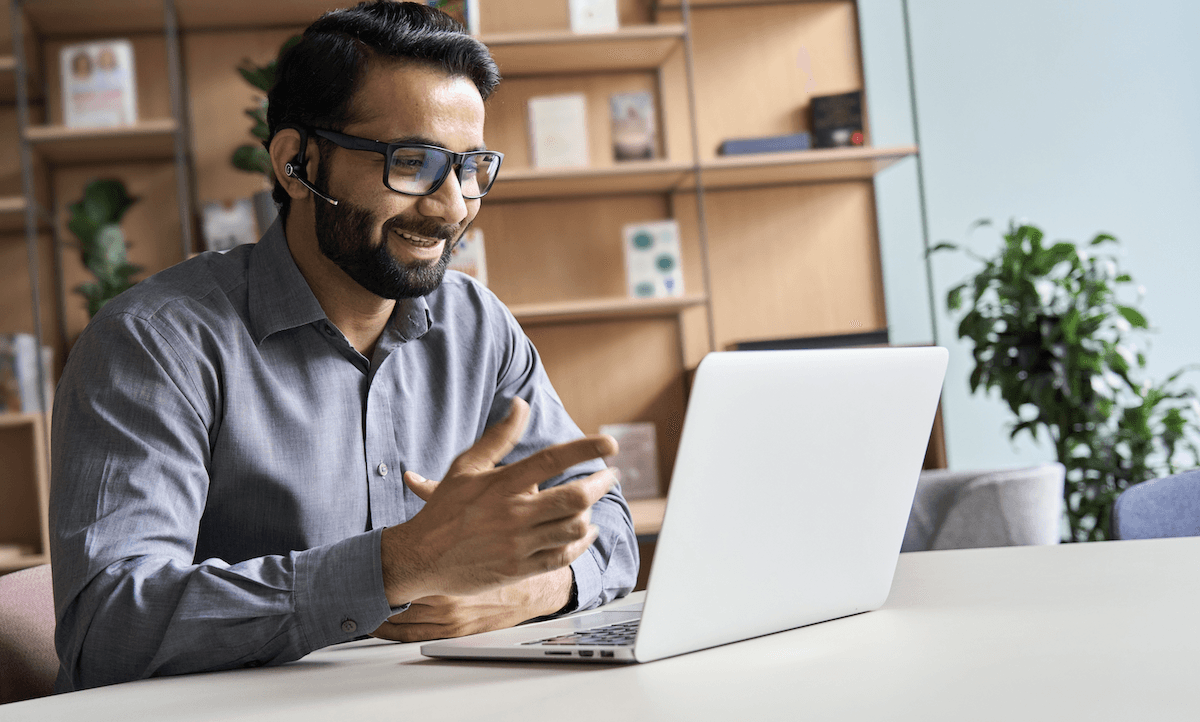 customer onboarding software: Smiling man using his laptop for a video call