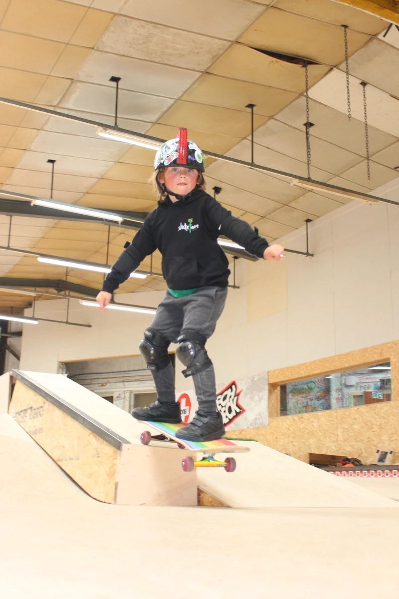 A young child balancing on a skateboard on the ramp at The Skate Farm in Haywards Heath