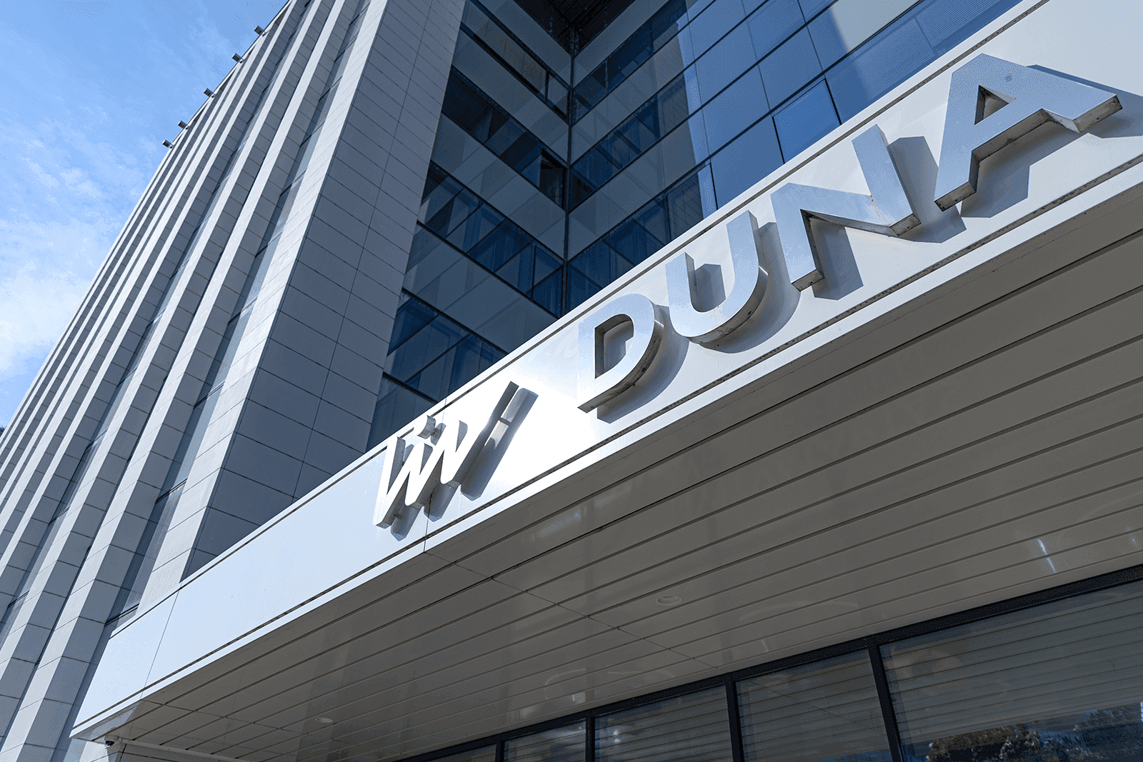  image of Imperial Dental's modern treatment room featuring blue dental equipment, a monitor with the clinic’s logo, and natural light from large windows overlooking a park.