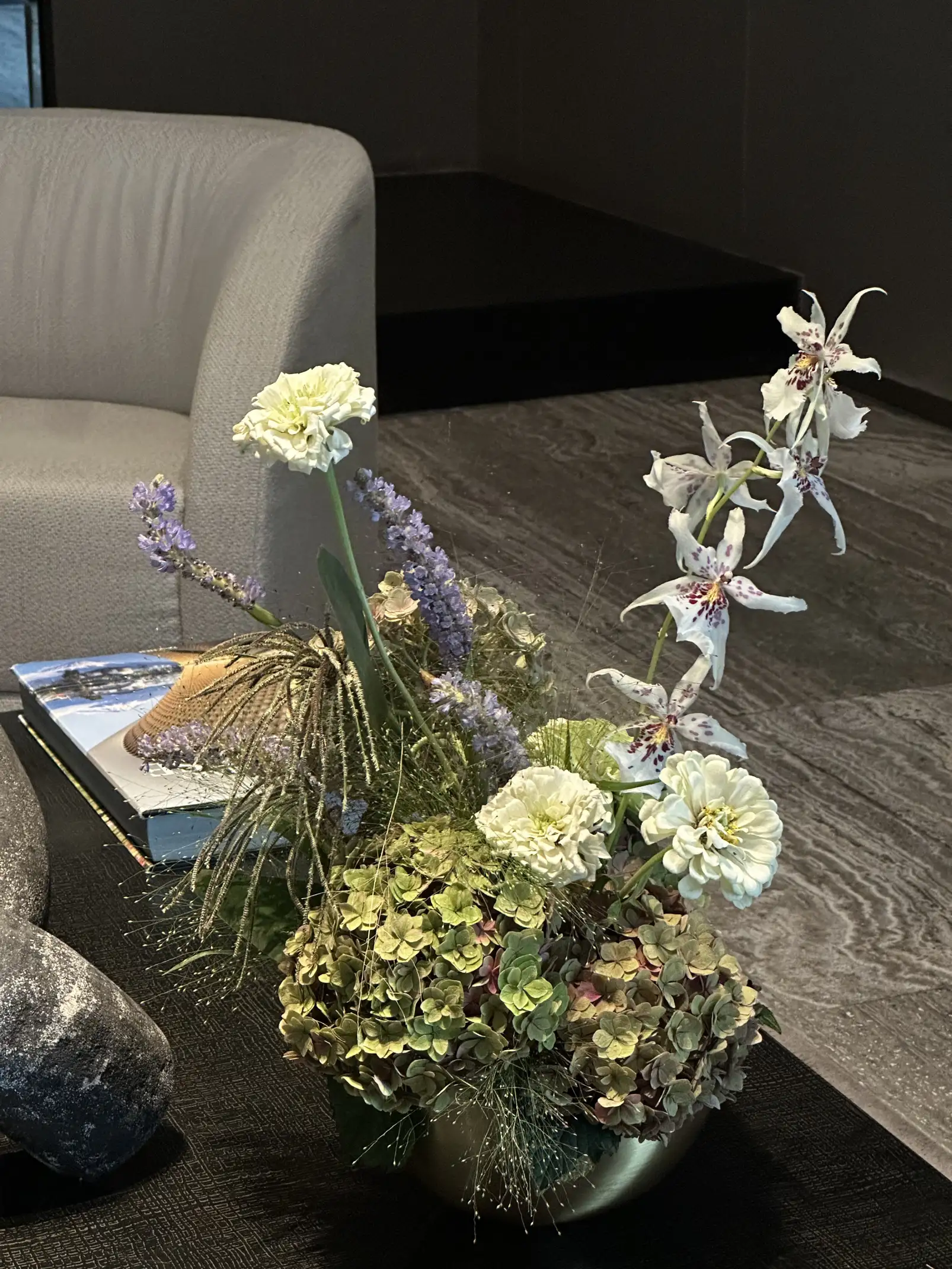 Arreglo floral con orquídeas, lavandas y hortensias en espacio contemporáneo para diseñadores de interiores que priorizan elegancia natural.