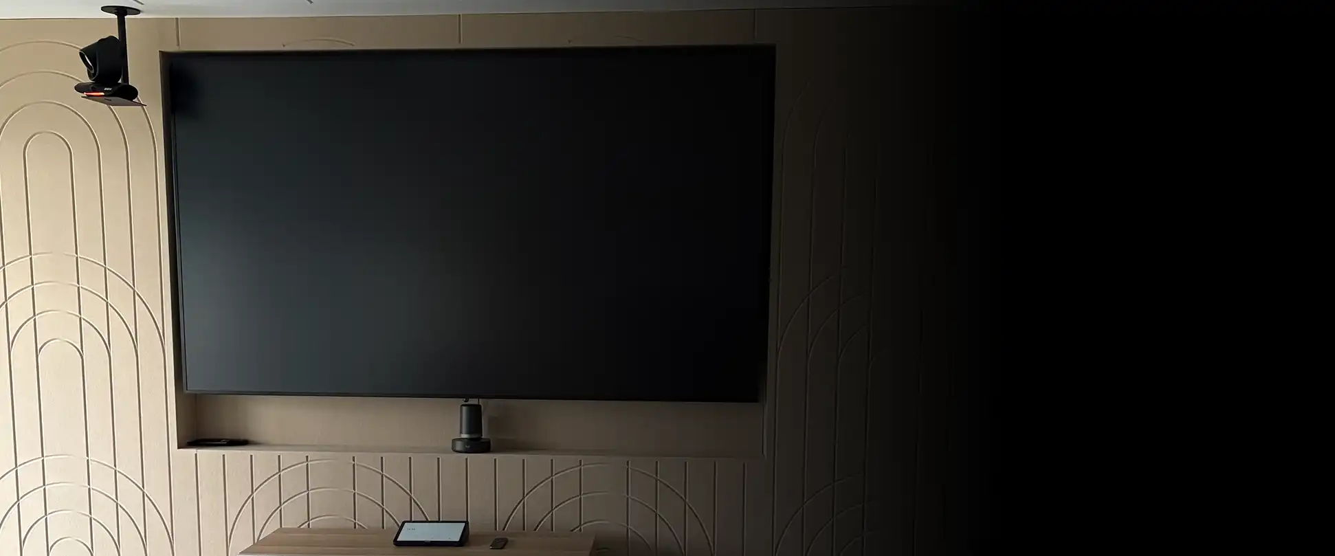 Meeting room with wall-mounted display, camera and control interface