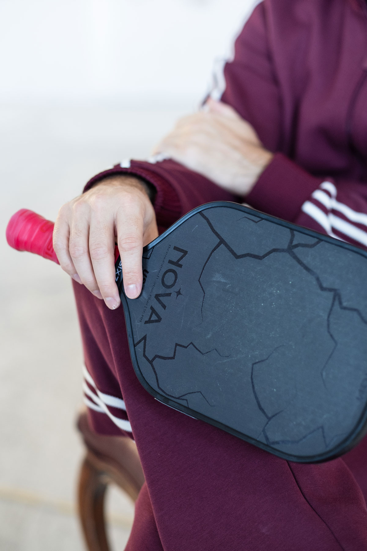 A couple of people walking down a street next to a fence