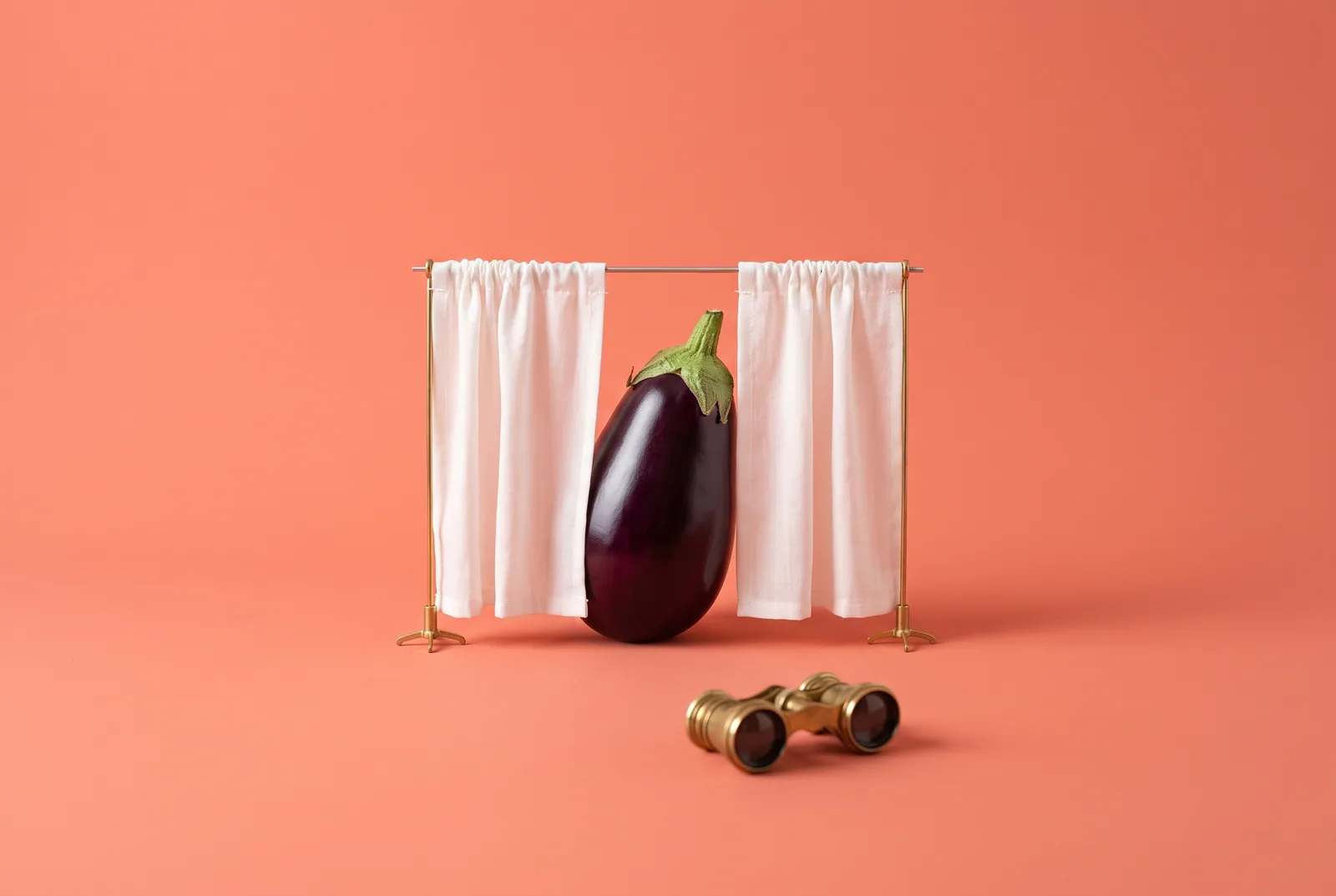 An eggplant behind half-drawn curtains with opera glasses in front, the privacy trade of porn accountability apps