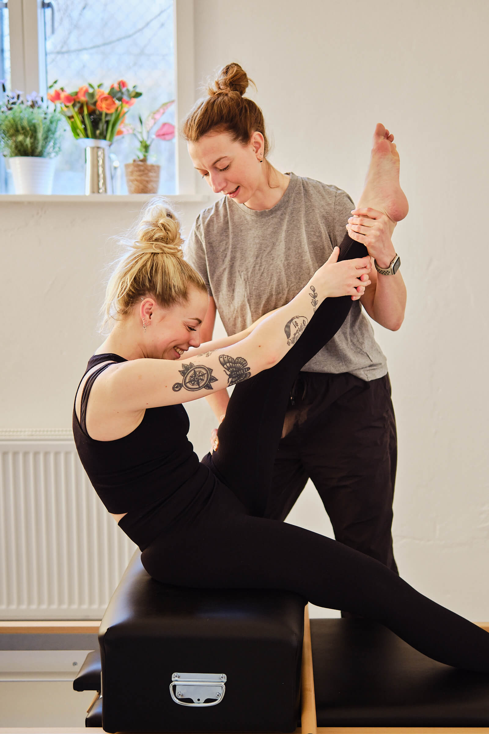 Pilates instruktør guider kvinde igennem øvelse