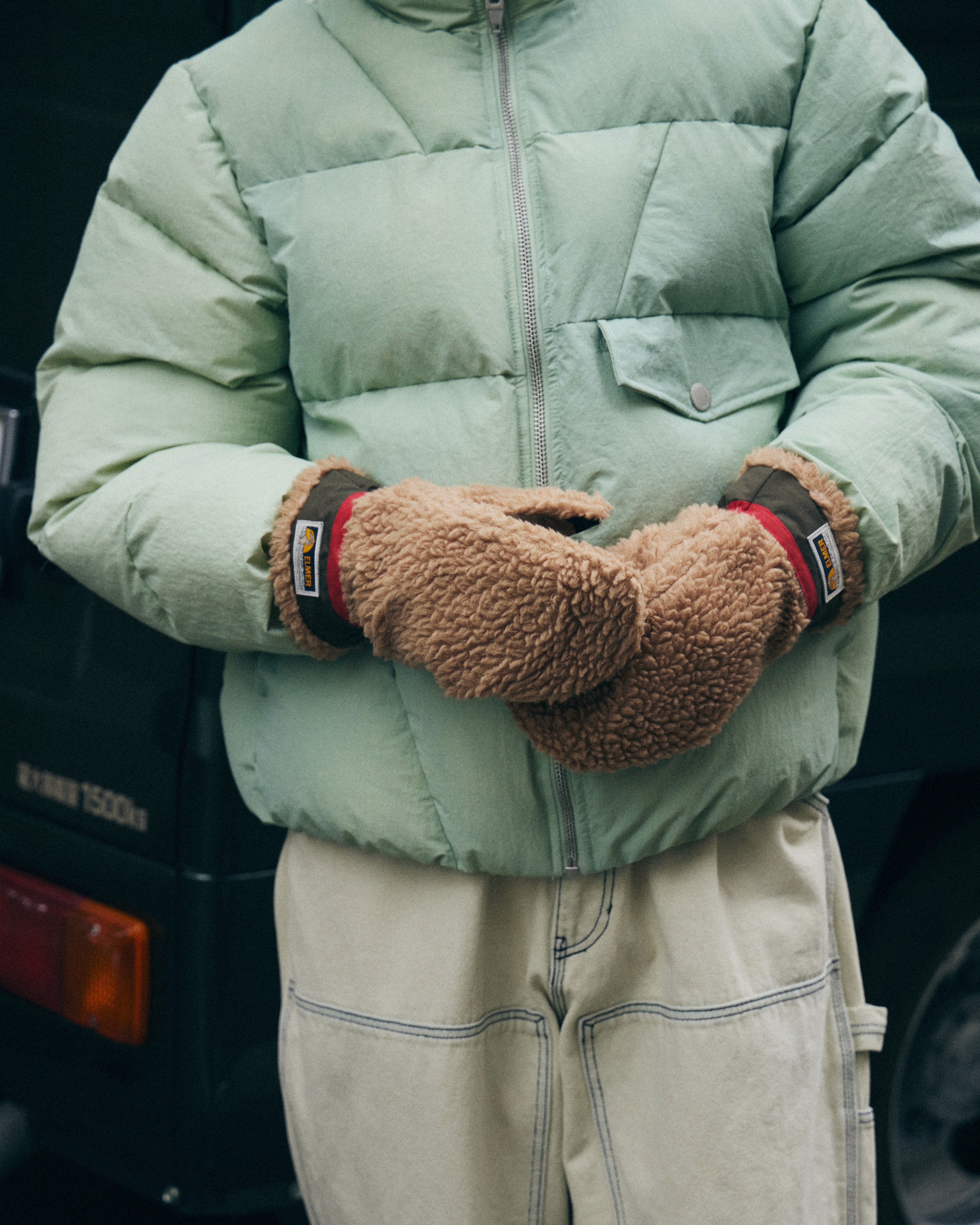Un homme porte des gants Elmer en forme de moufles, avec une texture laineuse