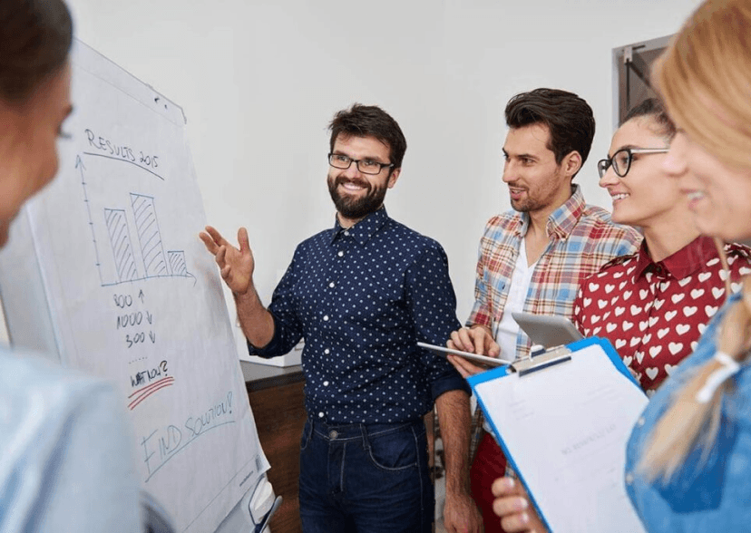 Dynamic e-commerce team analyzing performance metrics on a flipchart