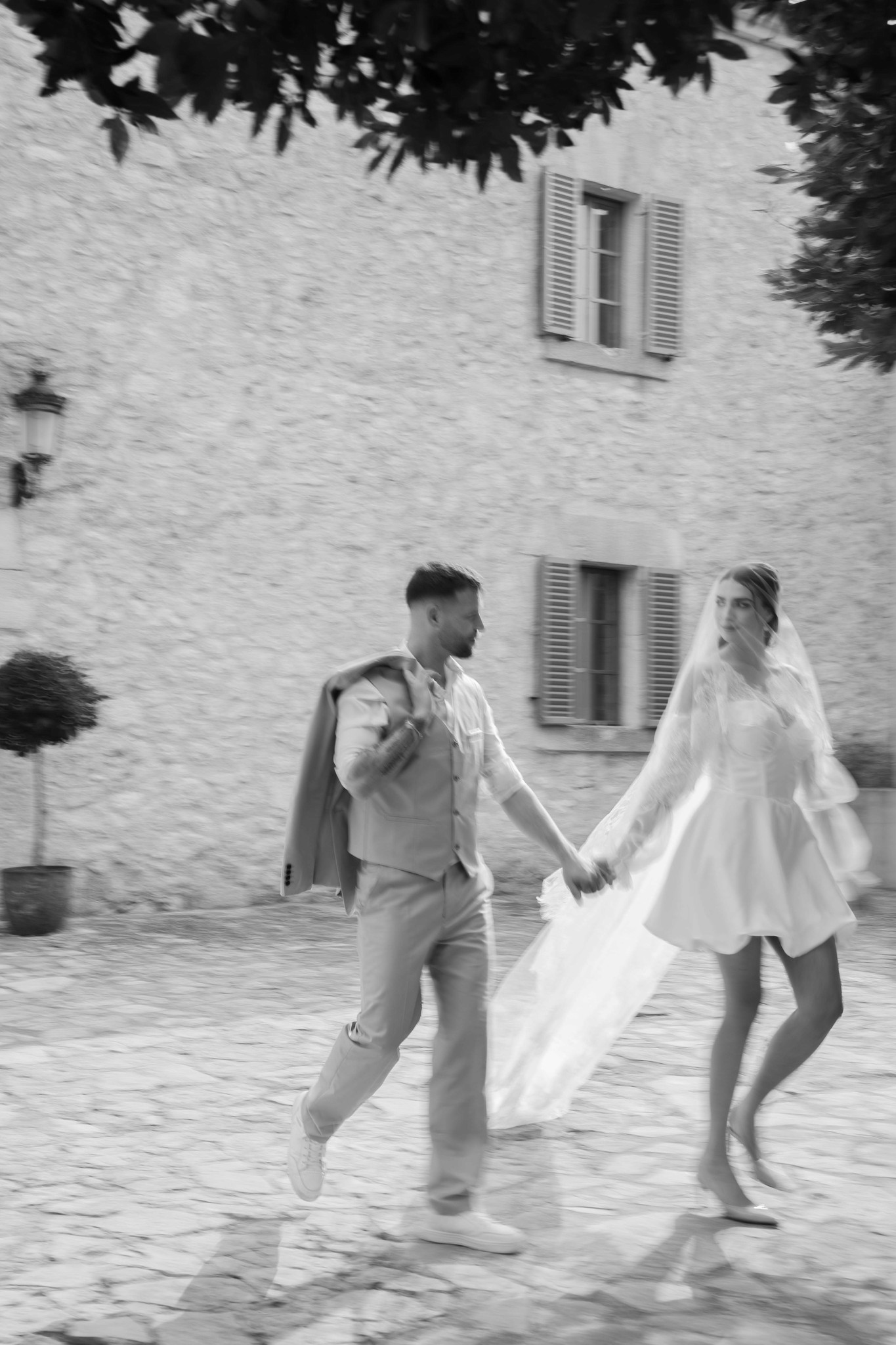 Emotionaler Schwarz-Weiß-Spaziergang des Brautpaares, ungestellt und natürlich, wie Blissxframes Photography echte Momente festhält.