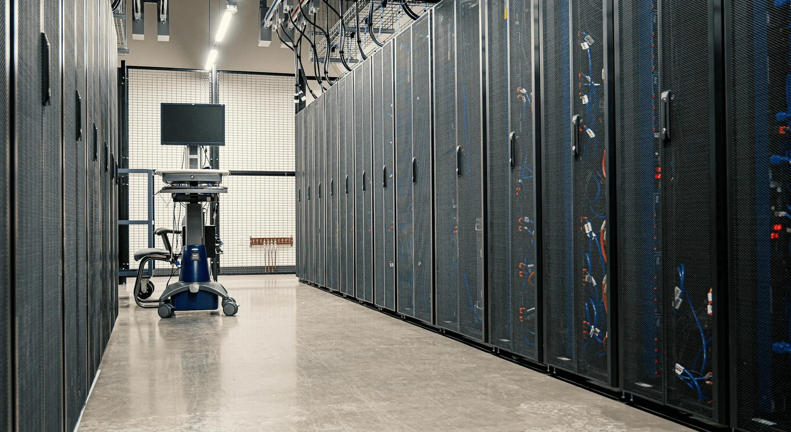 Modern data center corridor with server racks.
