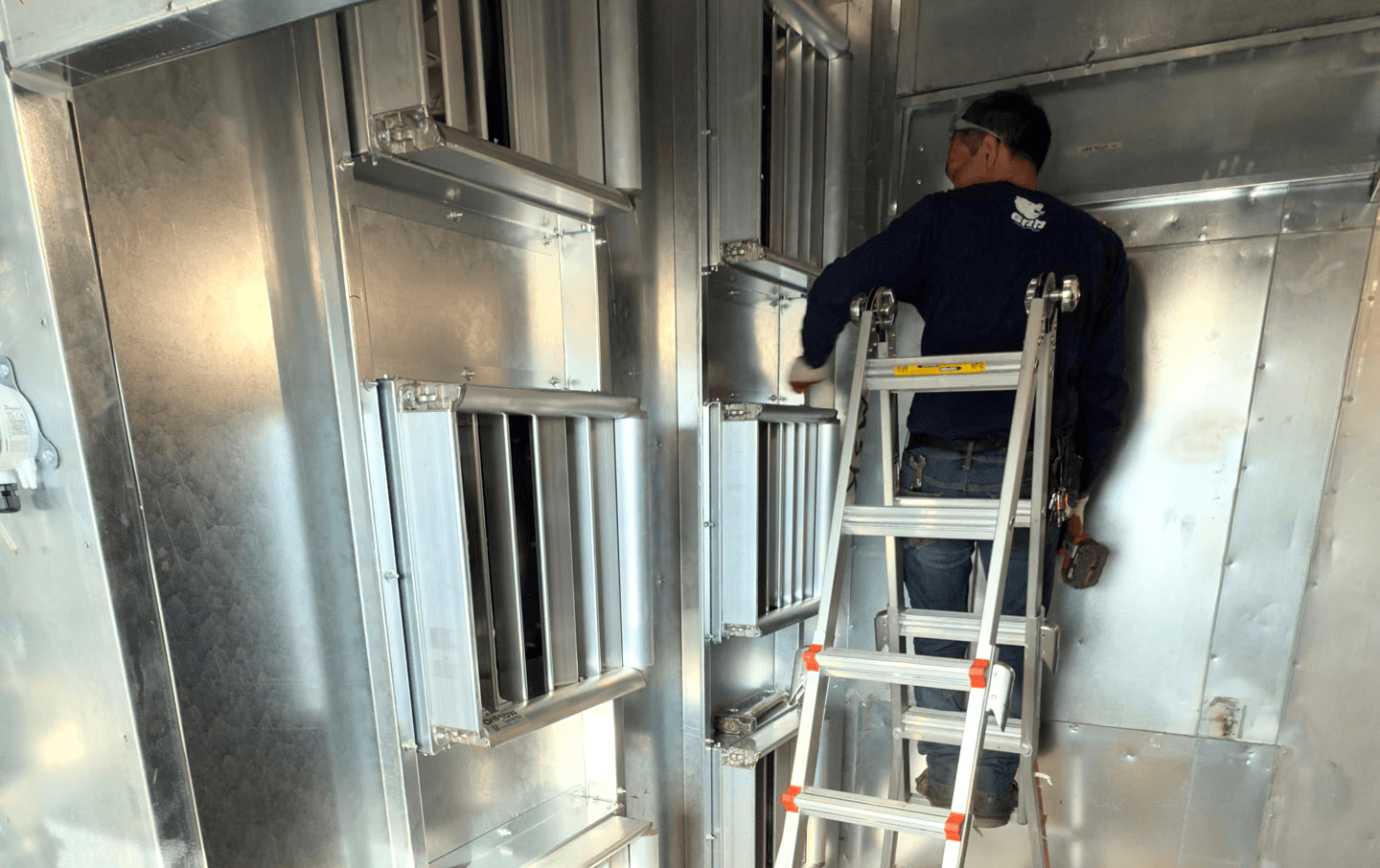 Technician installing a modular EC fan array inside a healthcare air handling unit during a live retrofit in New York City.