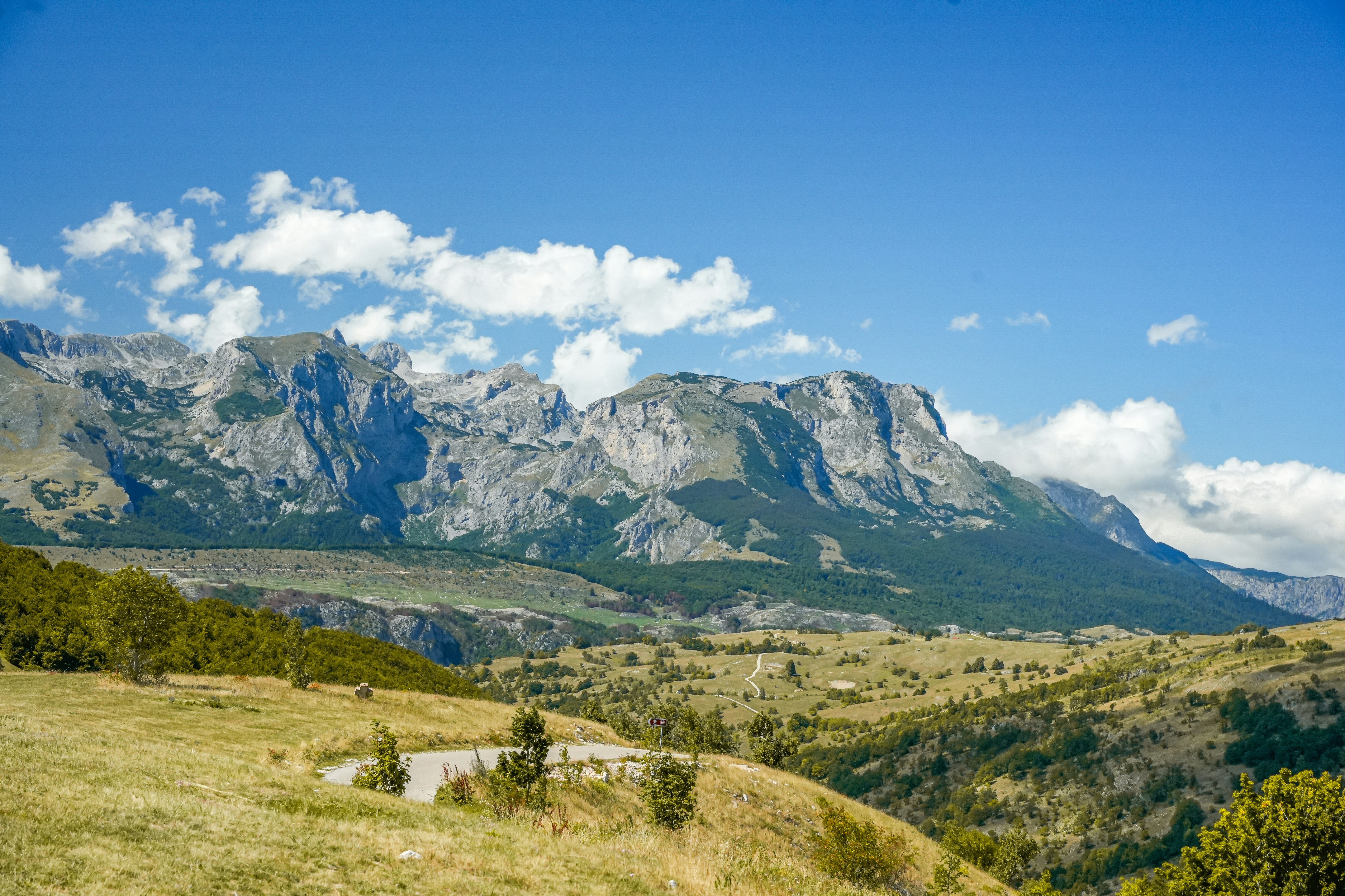 Majestic mountains under a clear blue sky with clouds.