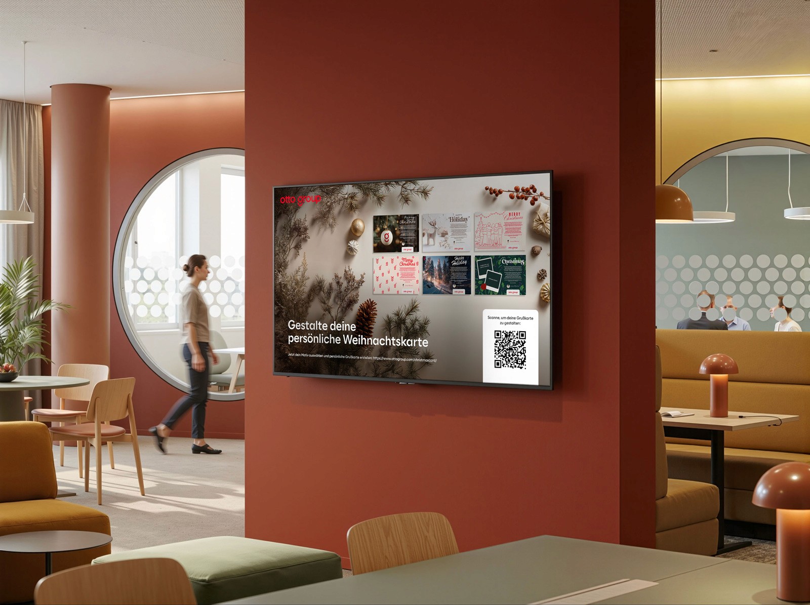 Ein großer digitaler Infoscreen in einem modern gestalteten Büro. Der Screen zeigt eine Übersicht verschiedener Weihnachtskarten-Designs mit dem Aufruf „Gestalte deine persönliche Weihnachtskarte“ und einem QR-Code. Im Hintergrund ist eine verschwommene Person in einem lichtdurchfluteten Atrium zu sehen.