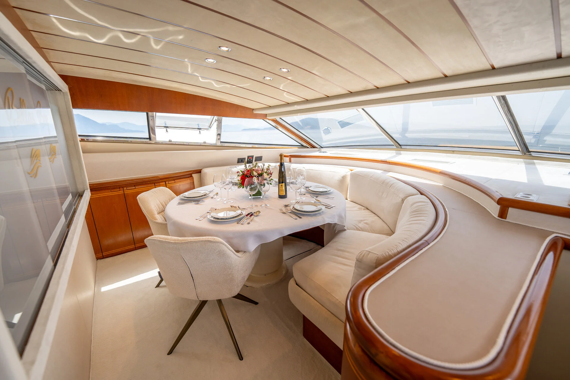 White Rock 36 speedboat with captain at helm cruising calm blue waters near Paros coastline with hills in background.