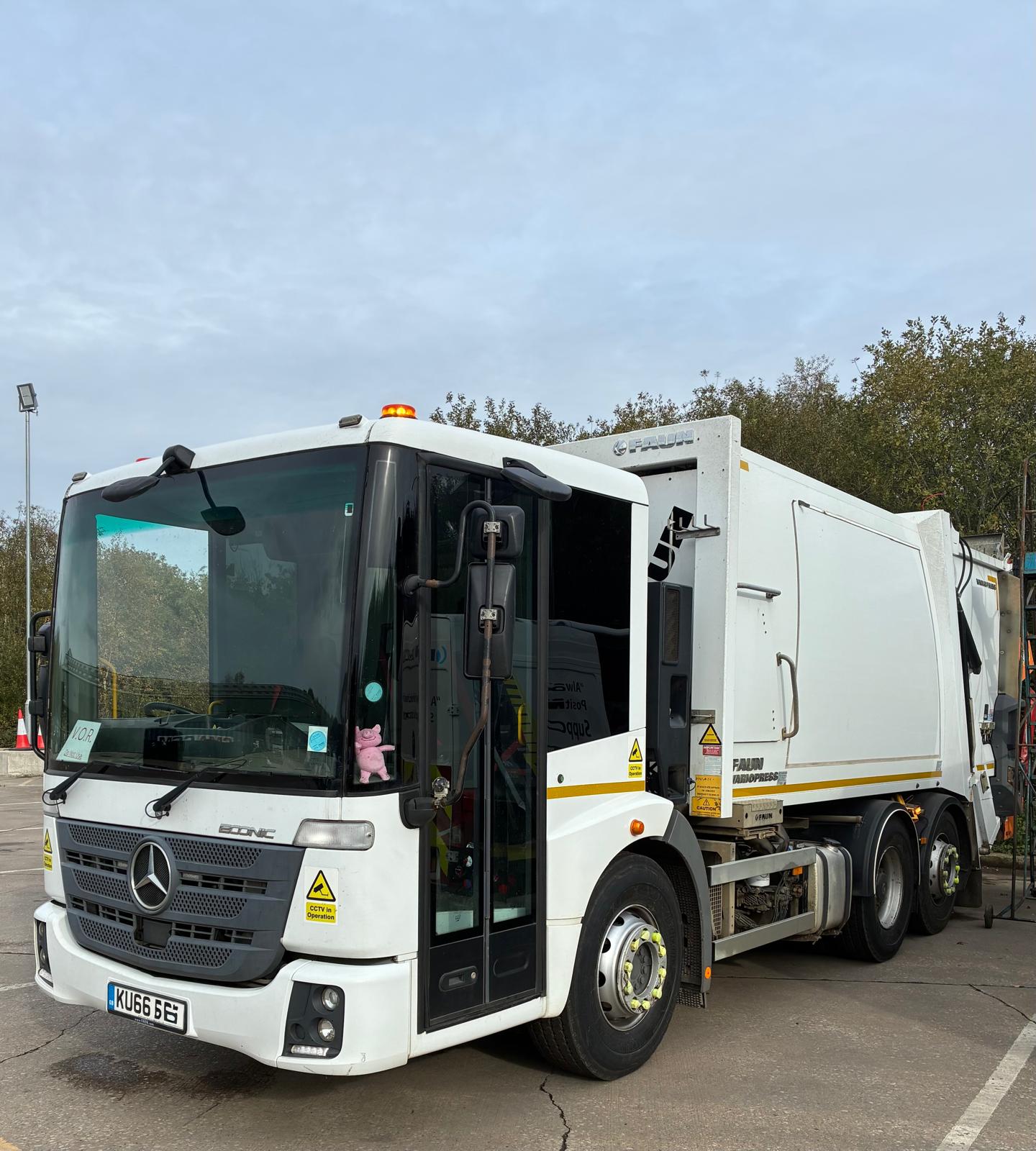 Aerial view of a winding road surrounded by dense green and yellow trees, showcasing nature’s vibrant colors.