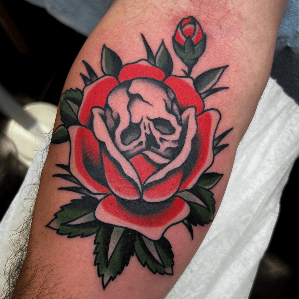 color tattoo of a skull inside of a rose