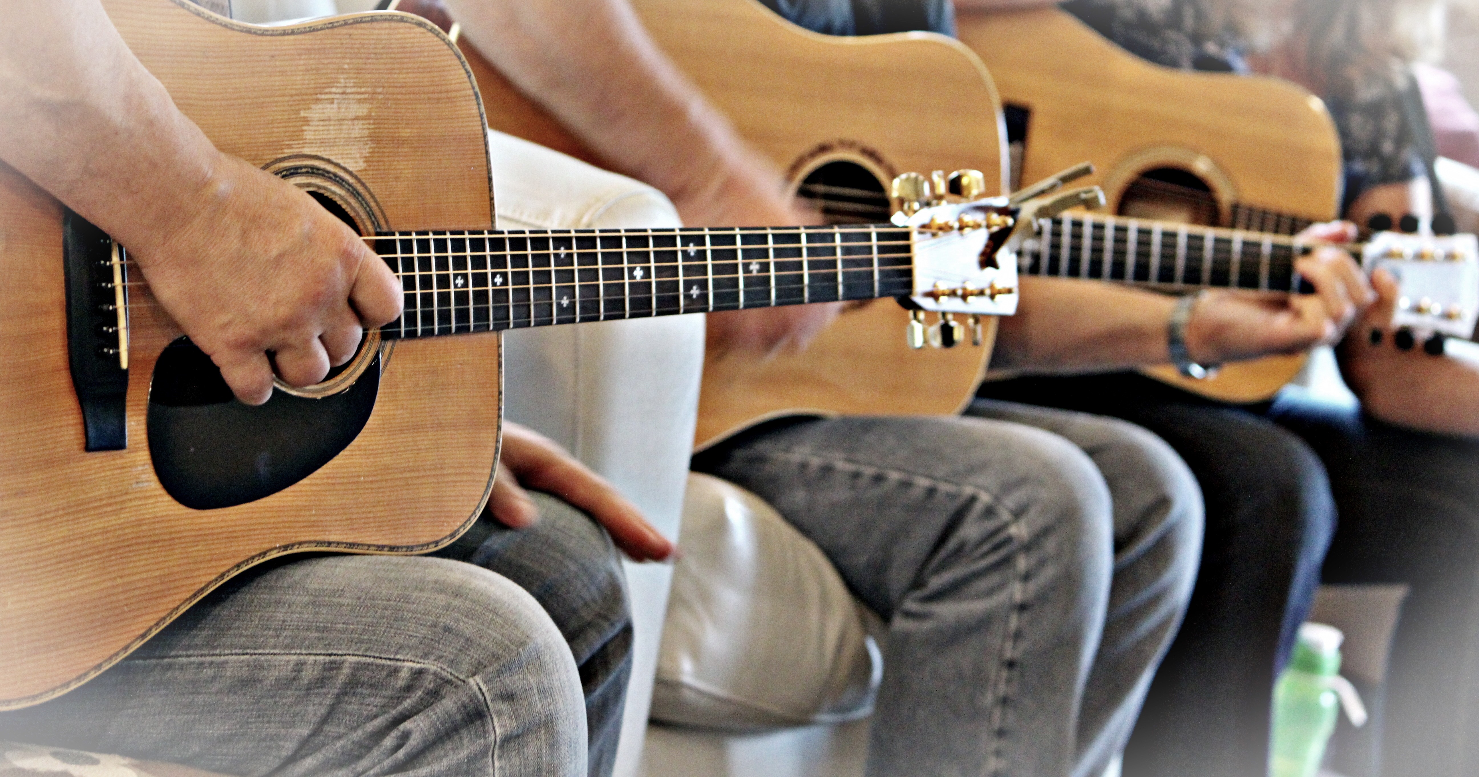 A line of people all playing the accoustic guitar