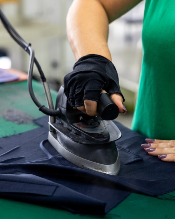 Artisan pressing a tailored garment by hand, ensuring clean lines and lasting structure — a hallmark of Don Marrón’s Italian craftsmanship.