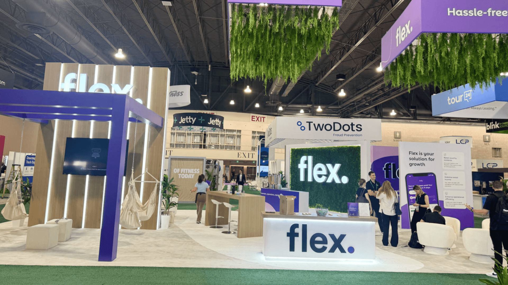 Flex NAA 2024 island booth view highlighting tall branded structures, hanging elements, and open corners