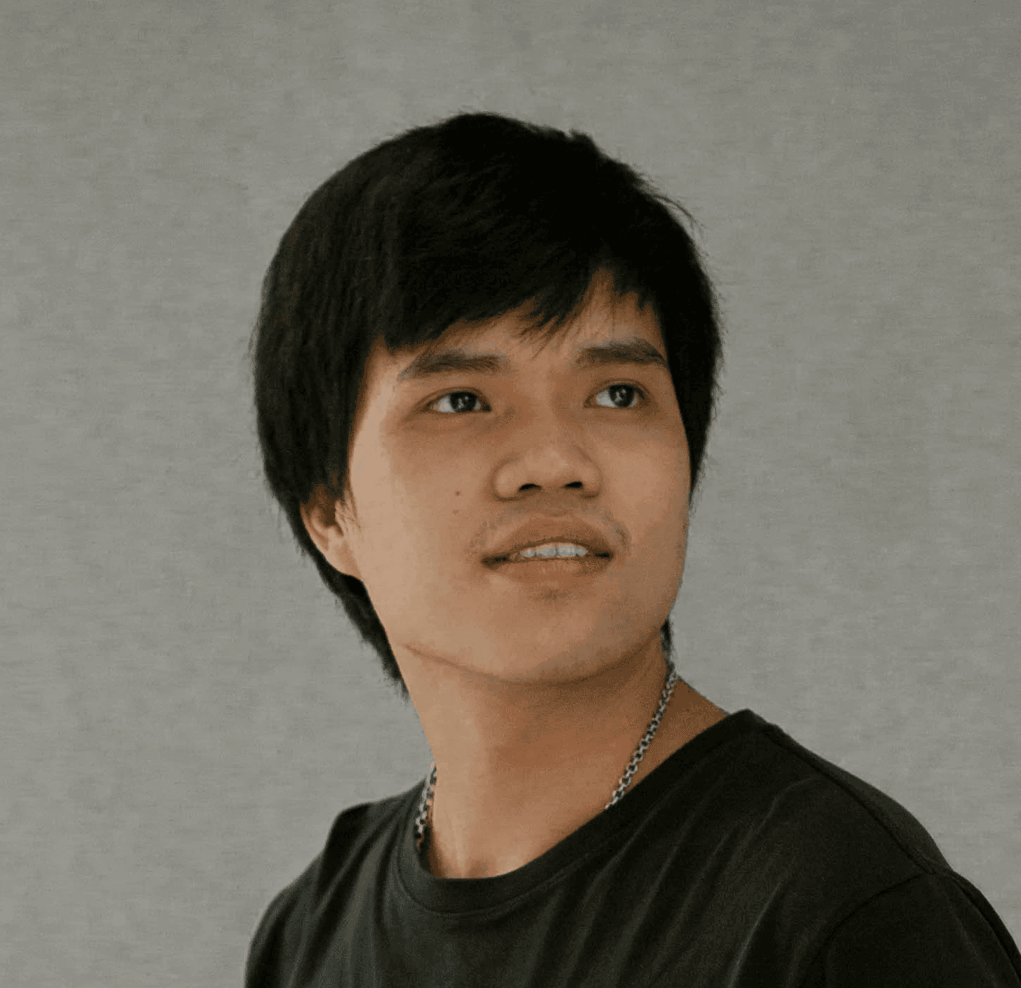 a young man standing in front of a wall