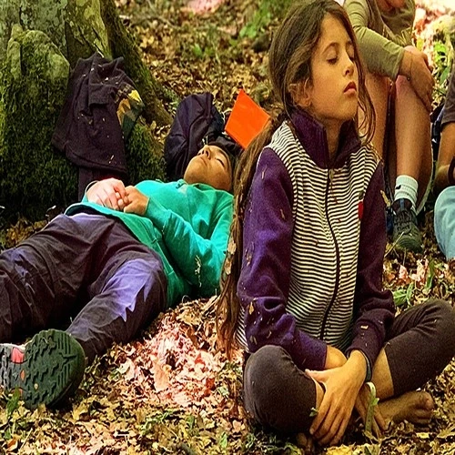 Bambini che riposano nel bosco durante un’esperienza di educazione outdoor e consapevolezza