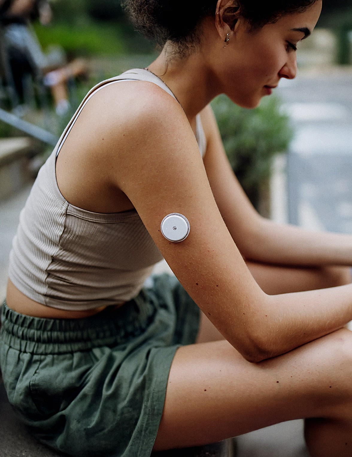 Woman wearing a continuous glucose monitor for metabolic health screening and personalized longevity testing.